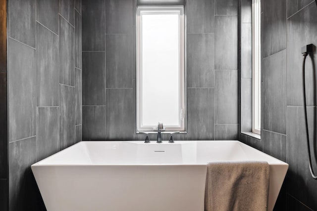 bathroom with tile walls and a washtub