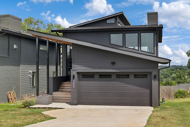 contemporary home with a garage and a front yard