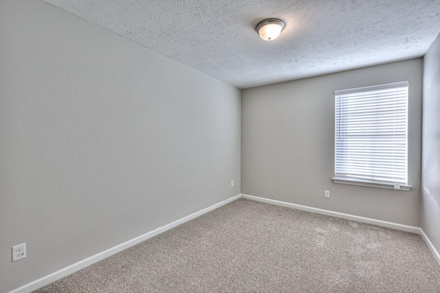 carpeted spare room featuring a textured ceiling