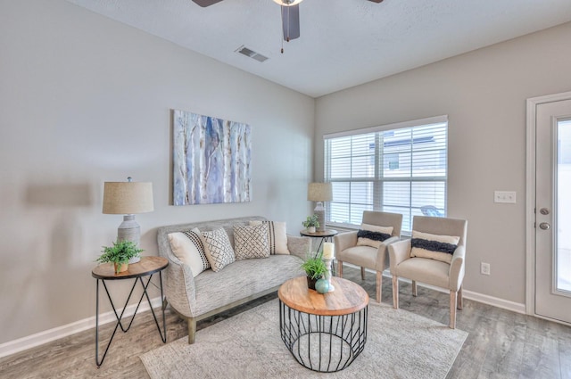 living room featuring ceiling fan and light hardwood / wood-style floors