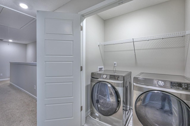 laundry room with washing machine and clothes dryer, light carpet, and a textured ceiling