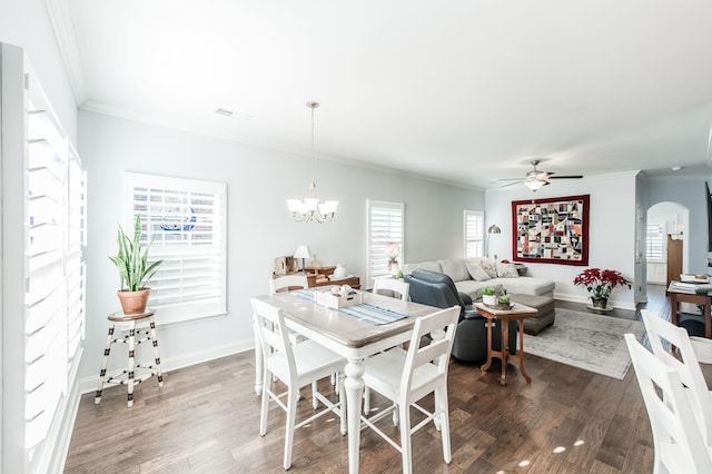 dining room with ceiling fan with notable chandelier, dark hardwood / wood-style flooring, and crown molding