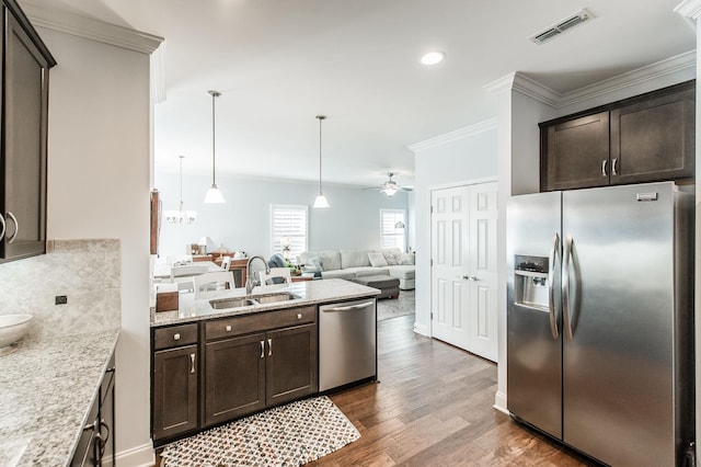 kitchen with appliances with stainless steel finishes, ceiling fan, pendant lighting, sink, and dark brown cabinets