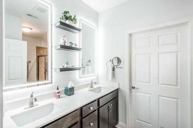 bathroom featuring a shower with door and vanity