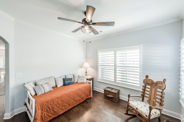 bedroom featuring dark hardwood / wood-style flooring, ceiling fan, and crown molding