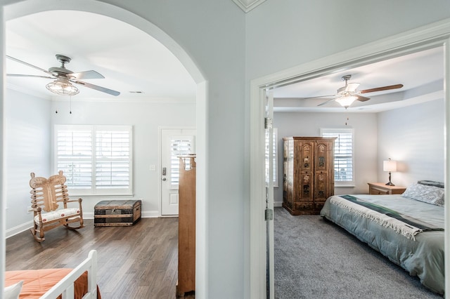 bedroom with dark hardwood / wood-style flooring, ceiling fan, and ornamental molding