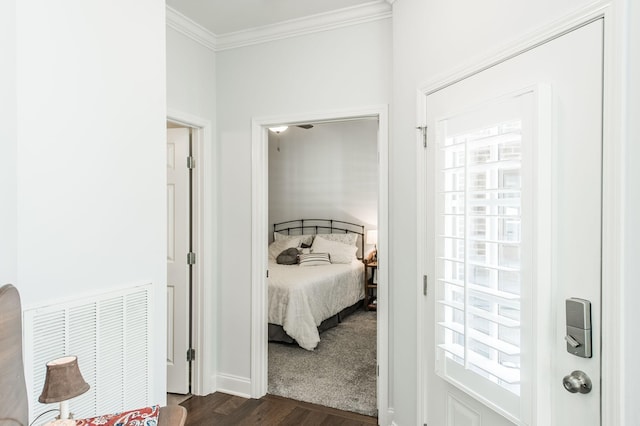 bedroom featuring crown molding and dark wood-type flooring