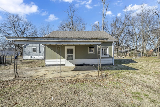 rear view of house featuring a yard and a carport