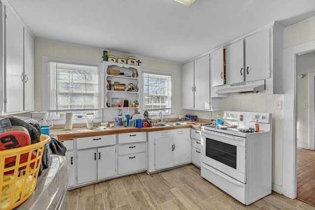 kitchen featuring sink, white cabinets, and white range with electric stovetop