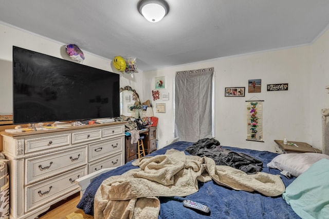 bedroom with ornamental molding and light hardwood / wood-style flooring