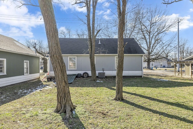 view of side of property with central AC unit and a lawn