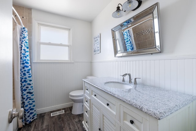 bathroom with toilet, vanity, and hardwood / wood-style floors