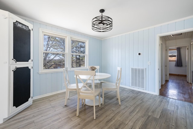 dining area with a notable chandelier, wood-type flooring, and plenty of natural light