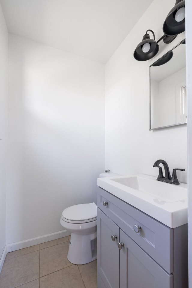 bathroom with toilet, vanity, and tile patterned floors