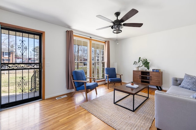 living room featuring ceiling fan and light hardwood / wood-style flooring