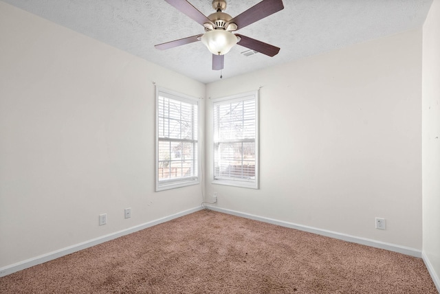 carpeted spare room with a textured ceiling and ceiling fan