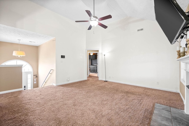 unfurnished living room with high vaulted ceiling, ceiling fan, and carpet