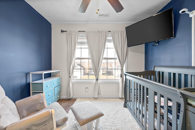 carpeted bedroom with a nursery area and ceiling fan