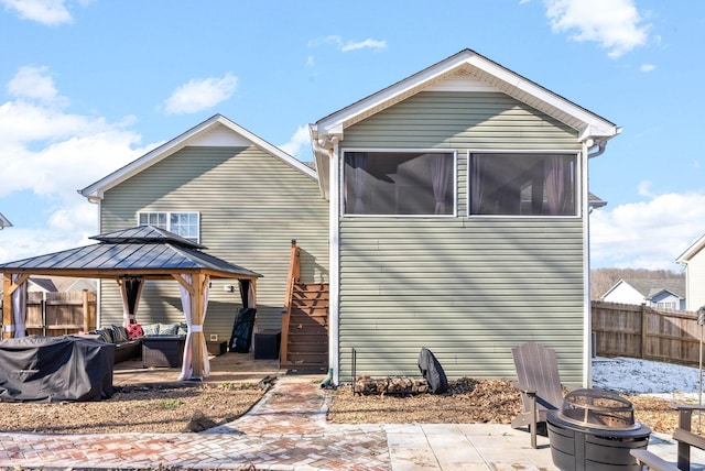 back of property featuring a fire pit, a patio area, and a gazebo