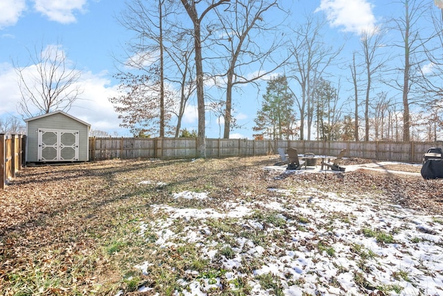 yard layered in snow with a storage shed