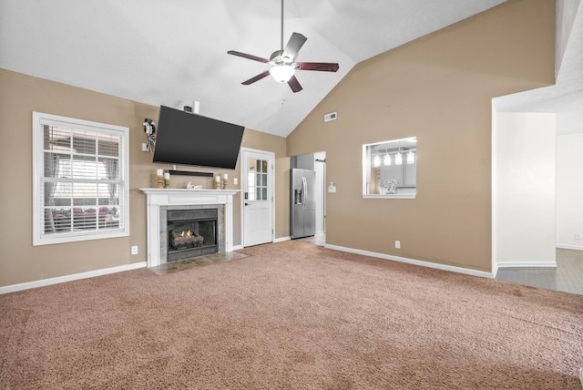 unfurnished living room featuring vaulted ceiling, a fireplace, ceiling fan, and carpet