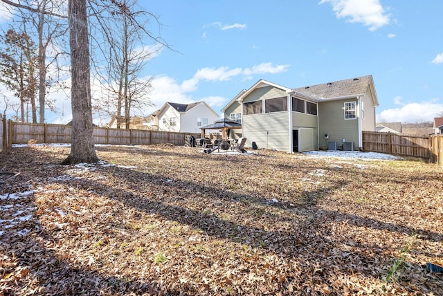 rear view of property with a gazebo, a sunroom, and central AC