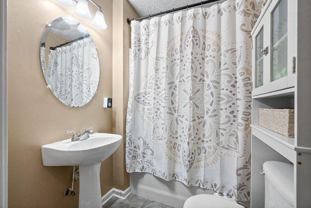 bathroom featuring a textured ceiling, shower / bath combination with curtain, and toilet