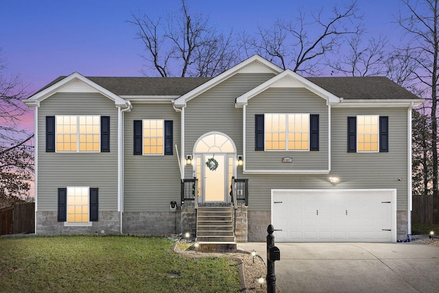 raised ranch featuring a lawn and a garage