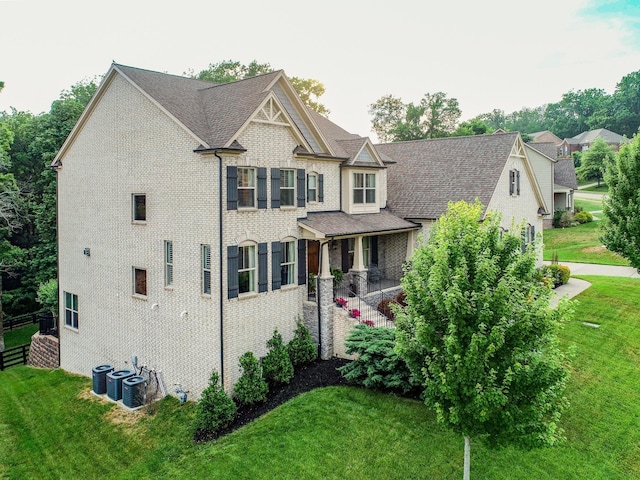 view of front of house with cooling unit and a front yard