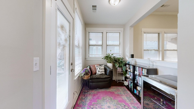 living area featuring crown molding