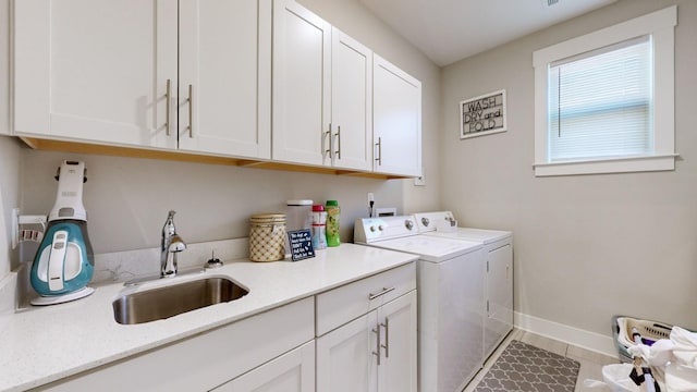 laundry room with cabinets, separate washer and dryer, tile patterned floors, and sink