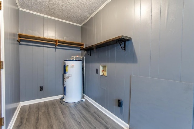 clothes washing area with laundry area, ornamental molding, wood finished floors, water heater, and washer hookup