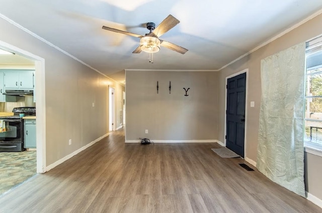 spare room with light wood-style floors, visible vents, crown molding, and baseboards