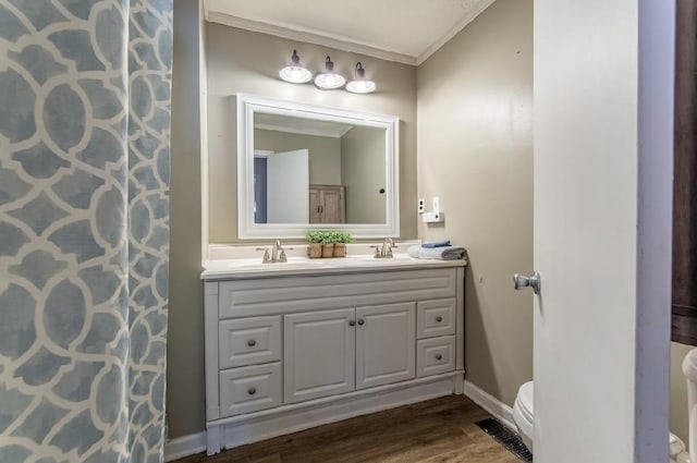 full bathroom featuring crown molding, visible vents, toilet, a sink, and wood finished floors