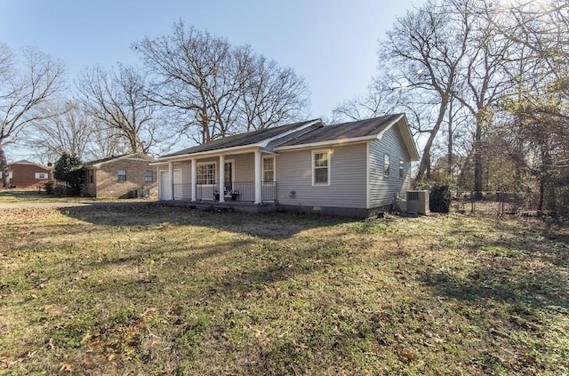 view of front of home featuring covered porch, a front lawn, cooling unit, and fence