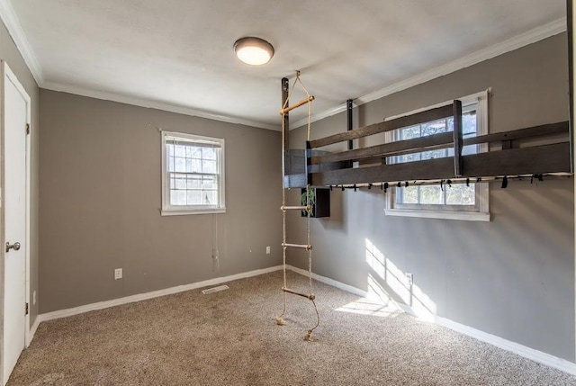 unfurnished bedroom with baseboards, carpet flooring, visible vents, and crown molding