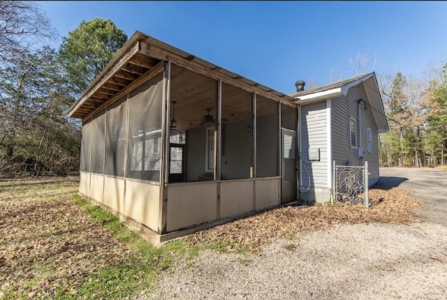 view of side of home with a sunroom and ceiling fan