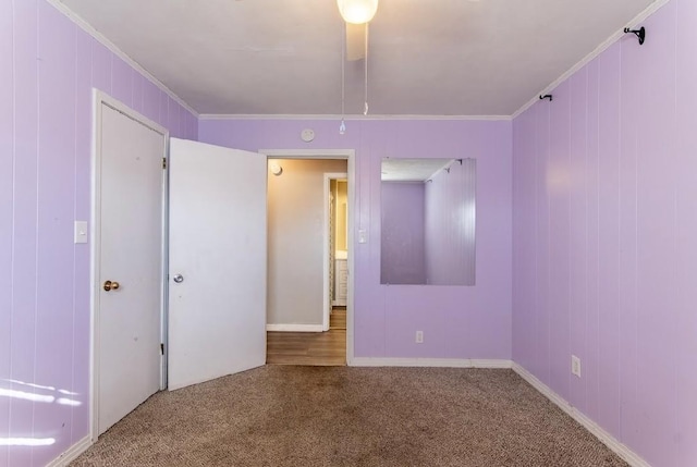 spare room featuring ornamental molding and carpet flooring