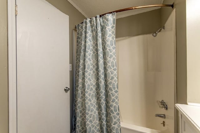 full bathroom with a textured ceiling and shower / bath combo with shower curtain