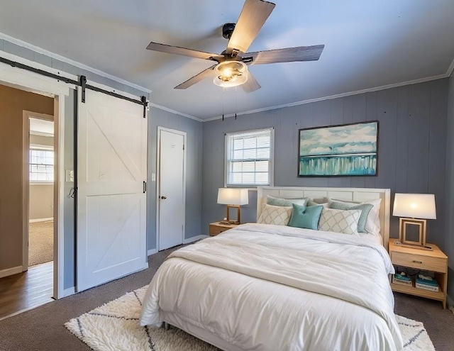 bedroom featuring a barn door, multiple windows, dark colored carpet, and crown molding