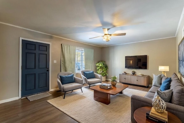 living area featuring ceiling fan, crown molding, baseboards, and wood finished floors