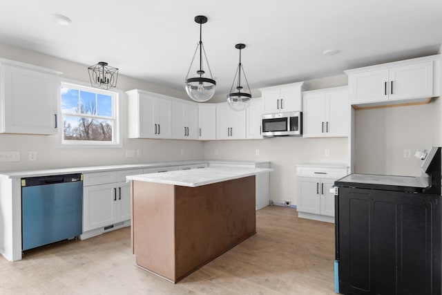 kitchen featuring an inviting chandelier, stainless steel appliances, a kitchen island, white cabinets, and decorative light fixtures