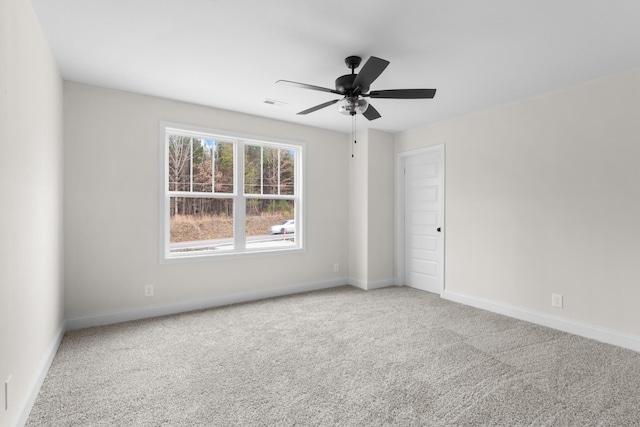 carpeted spare room featuring ceiling fan