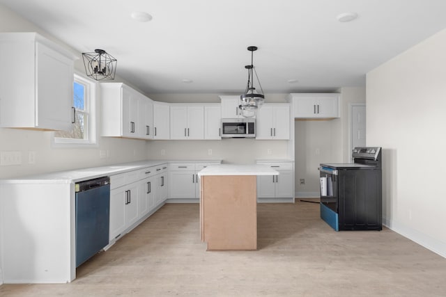 kitchen with stainless steel appliances, a kitchen island, decorative light fixtures, and white cabinetry