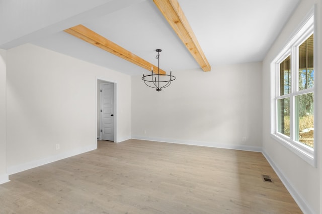 unfurnished dining area featuring light hardwood / wood-style floors, a wealth of natural light, and beamed ceiling