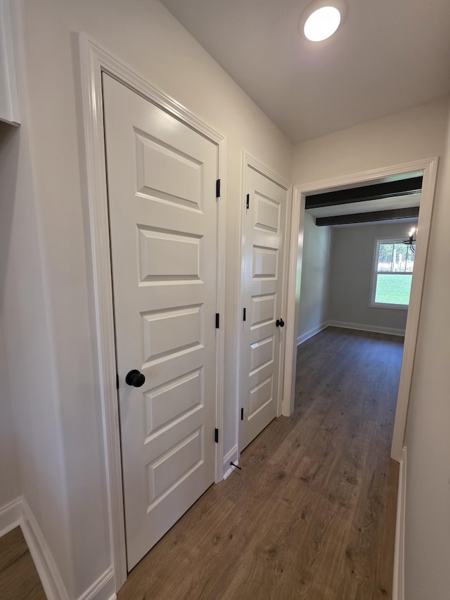 hall featuring dark wood-style flooring and baseboards