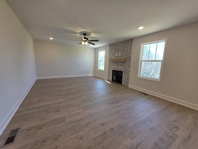 unfurnished living room featuring visible vents, dark wood-style flooring, baseboards, and ceiling fan