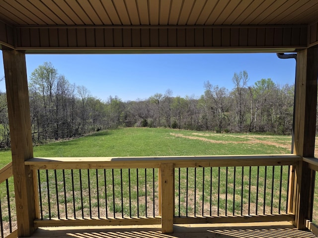 wooden deck featuring a yard and a forest view