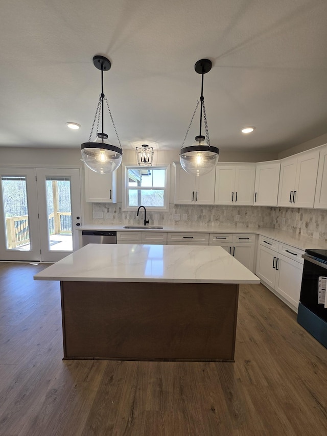 kitchen with dark wood-style flooring, backsplash, a kitchen island, dishwasher, and a sink