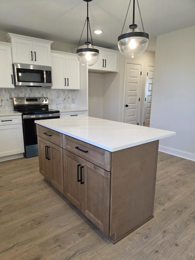 kitchen with white cabinets, wood finished floors, and appliances with stainless steel finishes